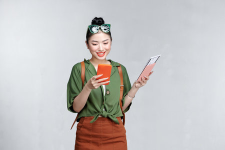 Cheerful woman makes check in online over the phone while holding her passportの写真素材