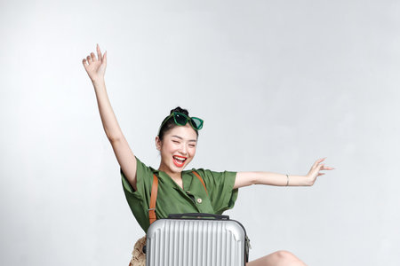 young tourist girl sitting back suitcase, pretending flying on a plane,の写真素材
