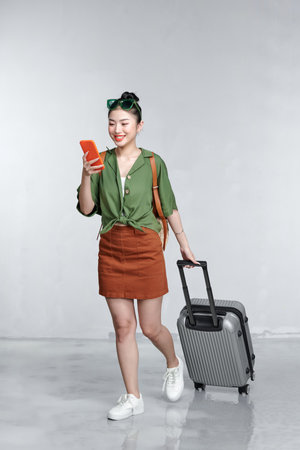 Cheerful woman makes check in online over the phone while holding her passportの写真素材