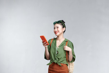 Photo portrait female keeping cell phone browsing internet walking along summer city streetsの写真素材