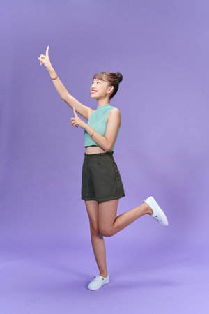 Photo of positive pretty lady jump two arm direct empty space isolated on violet color backgroundの写真素材