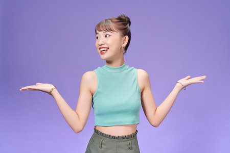 Young pretty girl hold hands measure scales promotion decide isolated over purple color backgroundの写真素材