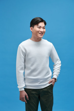 Attractive stylish smiling young man wearing a white t-shirt posing in the studioの写真素材