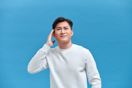 Asian people are upset and squeezing their heads with hands from a headache