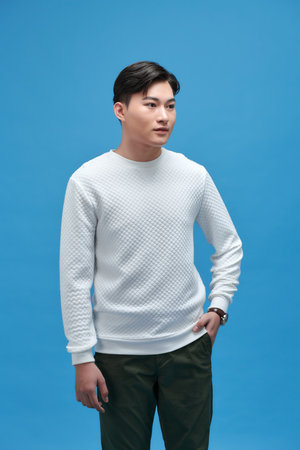 picture of a casual man with hand in pocket on blue backgroundの写真素材