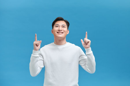 Excited man pointing a great idea - isolated over a blue backgroundの写真素材