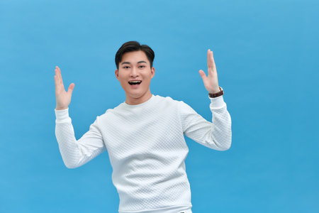 Young attractive handsome funny man excited fists up and celebrate hooray winner of tournamentの写真素材