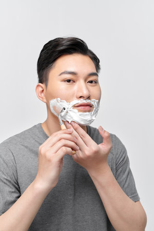 Handsome man enjoying morning bath routine, caring for appearance, healthy facial skinの写真素材