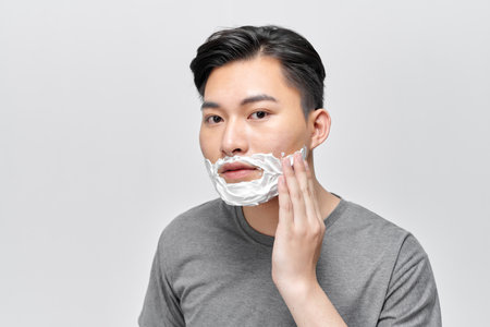 Shaving cream on face, hair and skincare for happy male model groomingの写真素材