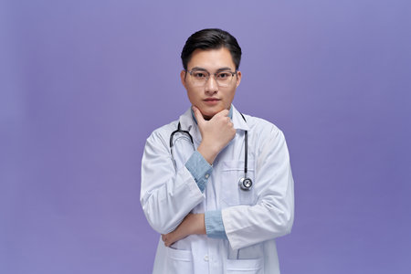 Asian male doctor in scrubs looking for idea thinking, searching for solutionの写真素材