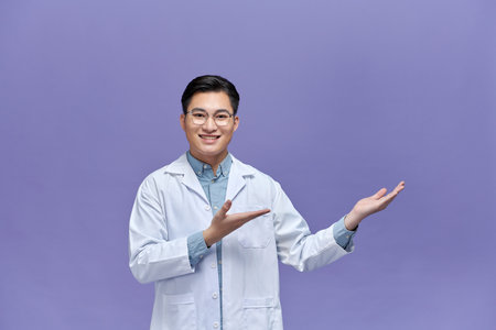 Confident young doctor showing something with his handの写真素材