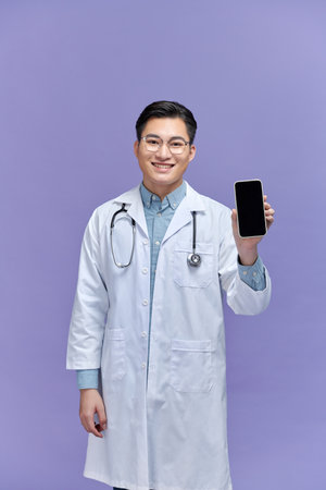 Male doctor man wears stethoscope, show mobile cell phone blank screenの写真素材