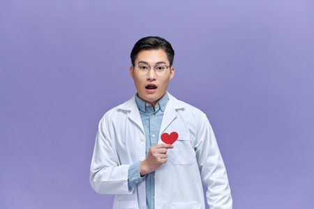 cardiologist doctor  man holding red heart, annoyed and frustrated shouting with anger,の写真素材