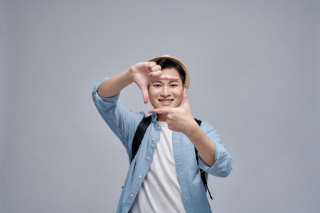 Closeup of confident happy man framing photograph white backgroundの写真素材