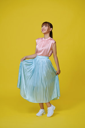 young girl happy positive smile go walk look empty space isolated over yellow backgroundの写真素材