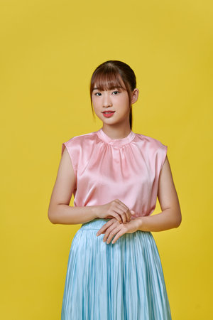 Young asian woman over isolated yellow background smilingの写真素材