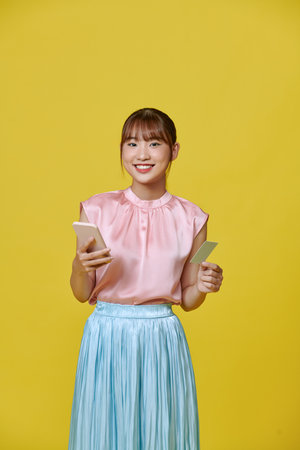 Holding credit card, portrait of asian happy cheerful woman holding credit cardの写真素材