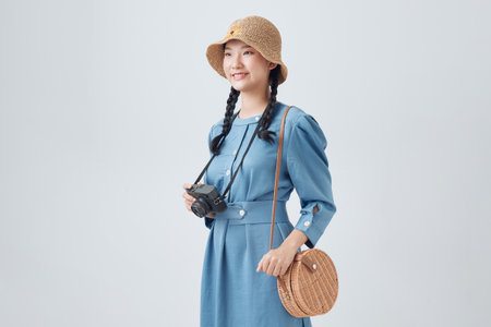 Portrait of smiling girl making photo with retro camera. Isolated on white background,の写真素材