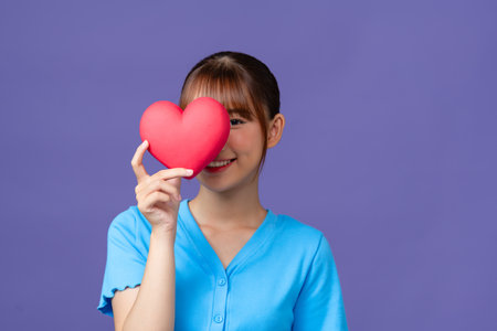 Attractive woman with heart, isolated on purple backgroundの写真素材