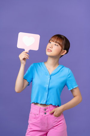 attractive young woman hold heart icon influencer blog isolated on purple backgroundの写真素材