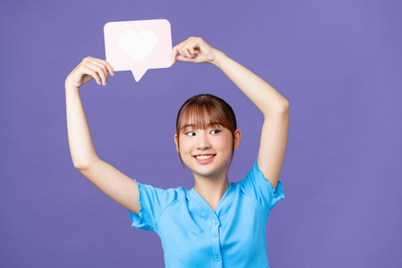 Photo of funny young asian lady show like wear blue crop-top isolated on purple backgroundの写真素材