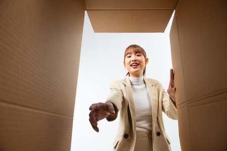 Excited girl unboxing cardboard delivery package.の写真素材