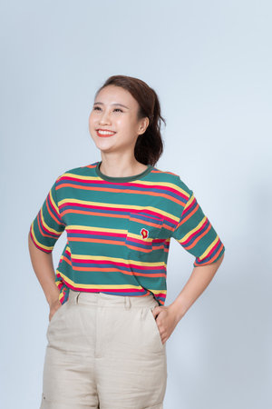Cute asian girl showing white healthy smile, grinning, standing over white backgroundの写真素材