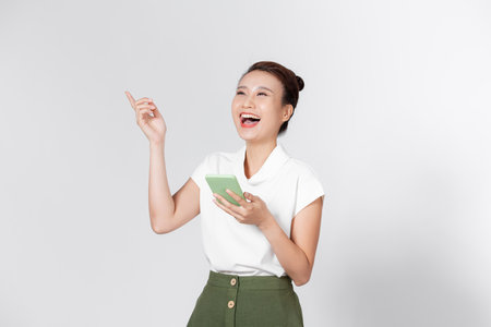 Photo portrait of surprised girl talking on phone isolated on white backgroundの写真素材