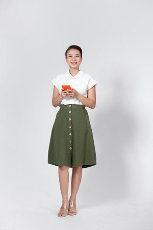 Beautiful smiling asian woman checking mail on mobile phoneの写真素材