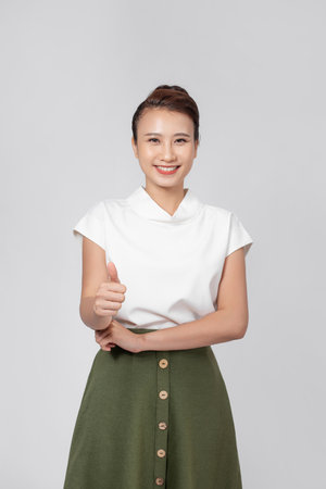 Happy young Asian woman feeling happiness and gesture thumb up on isolated white background with copy space.の写真素材