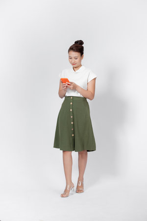 Asian woman using mobile phone application and pointing finger to smartphone isolated over white background.の写真素材