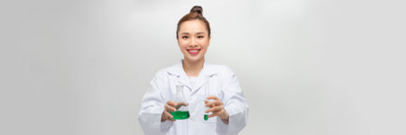 Female scientist in lab coat with chemical glassware. Isolated on white.の写真素材