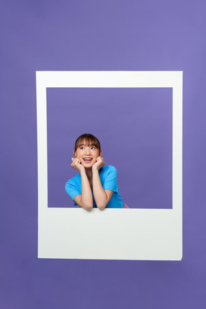 Smiling lady take photo of herself posing on camera isolated on purple backgroundの写真素材