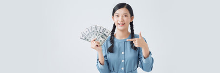 Portrait beautiful young asian woman show a lot of dollar cash or money on white backgroundの写真素材