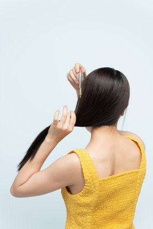 Woman Applying Moisturising Oil To Her Curly Hair,の写真素材