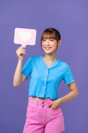 Photo of positive sweet lady smiling rising heart like card isolated on purple background