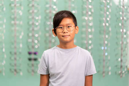 An asian boy trying on glasses in an optician store.の写真素材