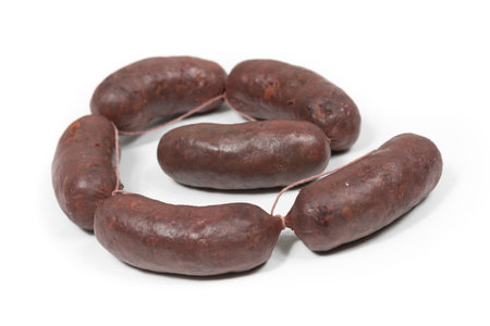 Six crude black pudding sausages on a white backgroundの写真素材