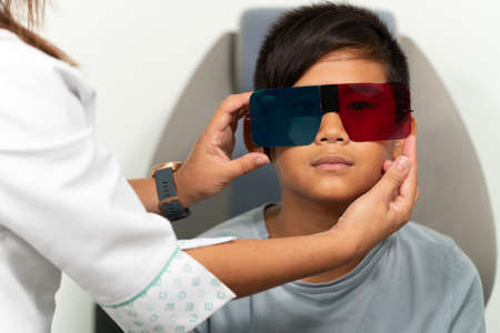 Asian boy in a duochrome test review with red and green 3D glassesの写真素材