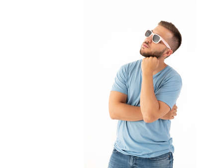 Pensive man looking up with a sunglasses on a white backgroundの写真素材