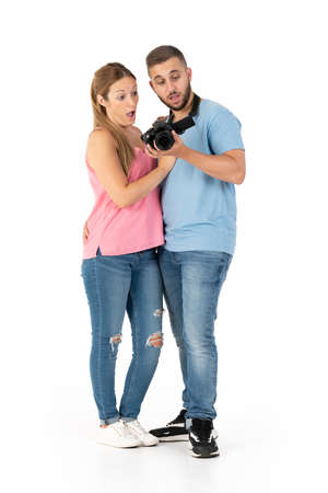 Surprised young couple looking at photos on their cameraの写真素材