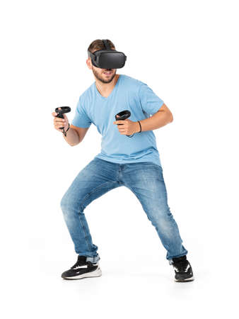 Young man playing with a VR glasses on a white backgroundの写真素材