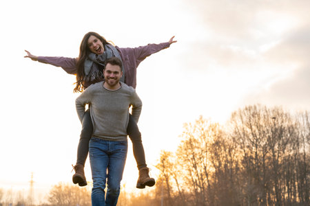 Young heterosexual couple walking and playing in a park on valentines dayの写真素材