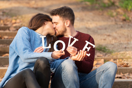 Young couple playing with some big love white letters