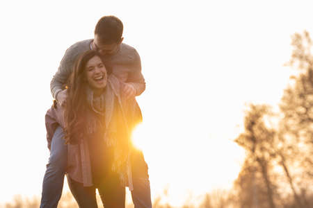 Young heterosexual couple walking and playing in a park on valentines dayの写真素材