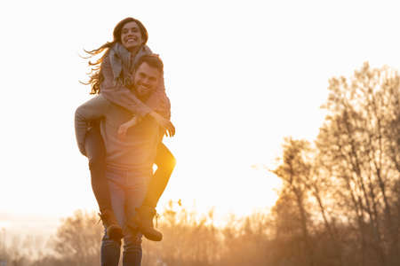 Young heterosexual couple walking and playing in a park on valentines day