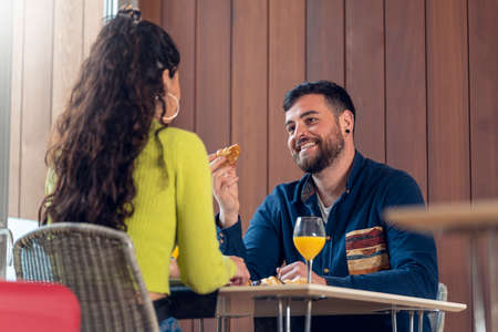 Young tourist couple talking and having breakfast in a hotelの写真素材