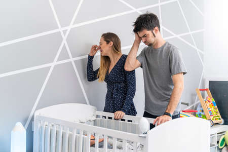 mother and father in front of their sons crib horrified by the bad smell
