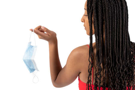 Young mulatto woman with a mask hanging in her handの写真素材