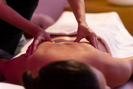 Woman physiotherapist doing a massage to another woman in her backの写真素材